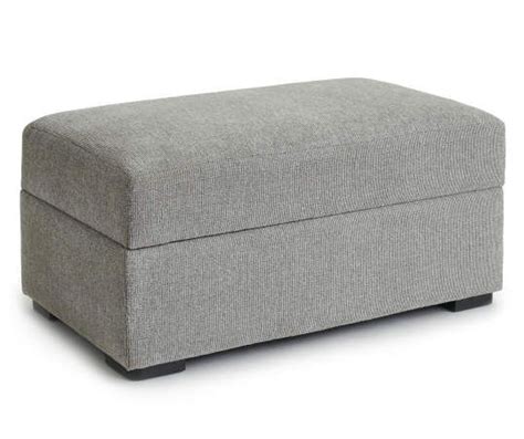 A Grey Ottoman Sitting On Top Of A White Floor