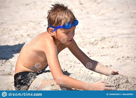 Il Ragazzino Sulla Spiaggia Gioca Il Bambino Nei Bicchieri D Acqua Sul Mare Immagine Stock
