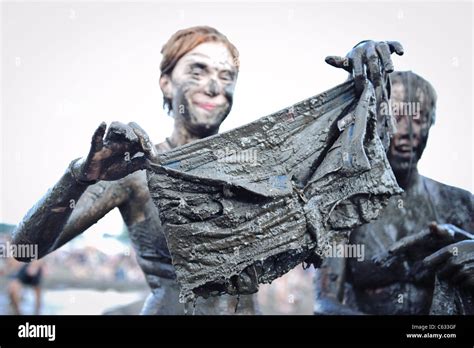 woman showing her clothes covered in mud at the przystanek woodstock europe s largest open air