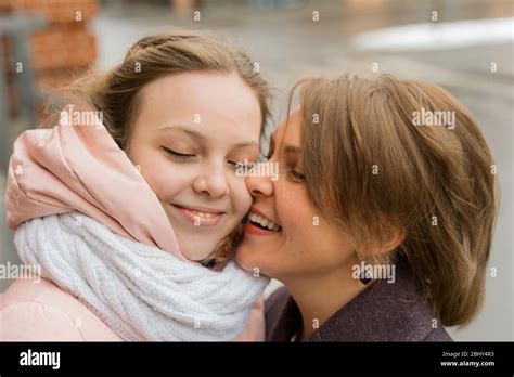 Mature Mother Hugs And Kisses Her Adult Daughter On The Forehead Girl