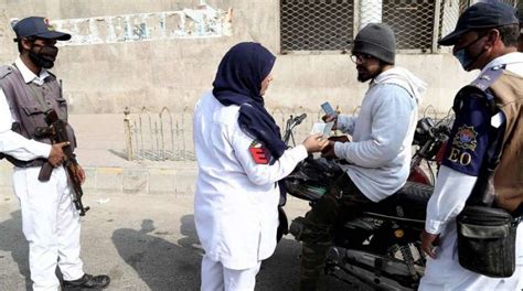 کراچی، خاتون ٹریفک پولیس اہلکار بغیر ہیلمنٹ کے موٹر سائیکل چلانے پر شہری کا چالان کر رہی ہے۔