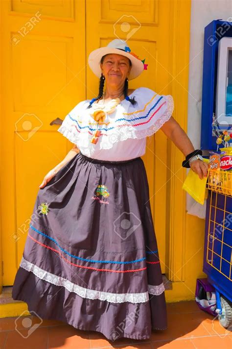 medellin january 2018 a woman in traditional colombian dress welcomes tourists in the small