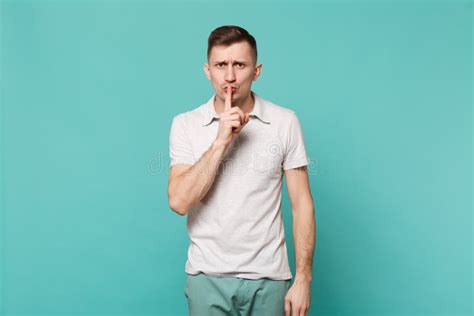 Young Man In Casual Clothes Saying Hush Be Quiet With Finger On Lips