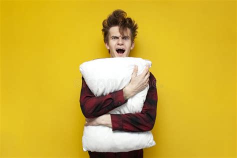 Sleepy Tired Guy Yawns And Holds A Pillow On Yellow Isolated Background