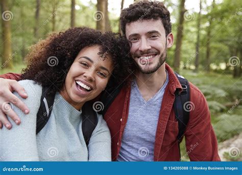A Young Adult Mixed Race Couple Laughing To Camera During A Hike In A