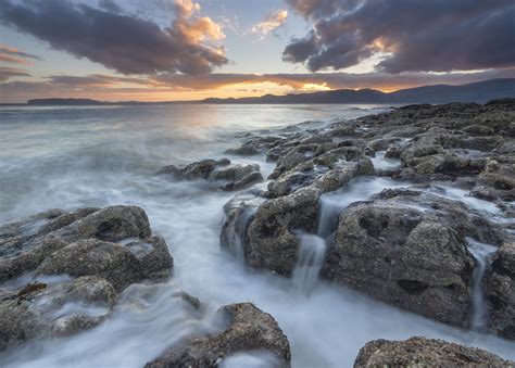 Flow Of Water On Gray Rocks Under White Clouds And Blue Sky During