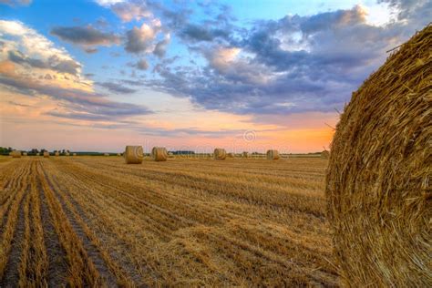 Sunset Over Farm Field With Hay Bales Stock Photo Image Of Dramatic