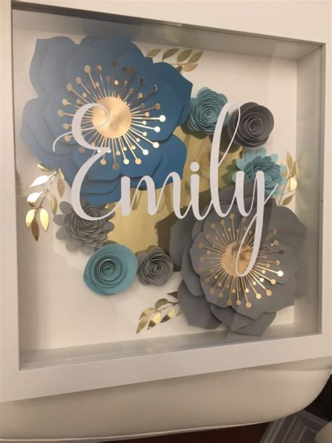 an image of some paper flowers in a frame with the word family written