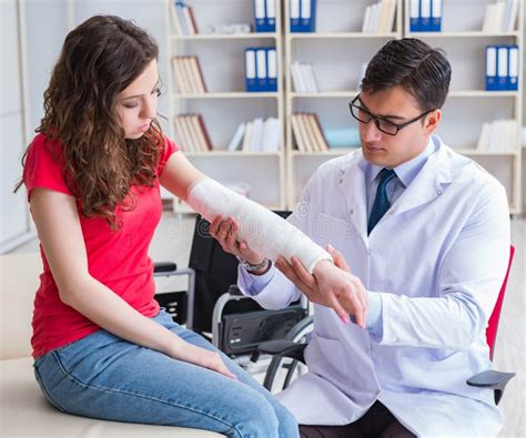 Doctor And Patient During Check Up For Injury In Hospital Stock Photo