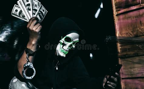Hacker Holding Money And Using Laptop For Hacking Data Stock Photo