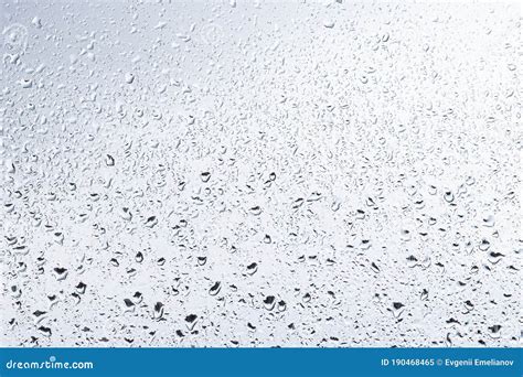 Rain Drops On Window Glasses Surface With Cloudy Sky Background