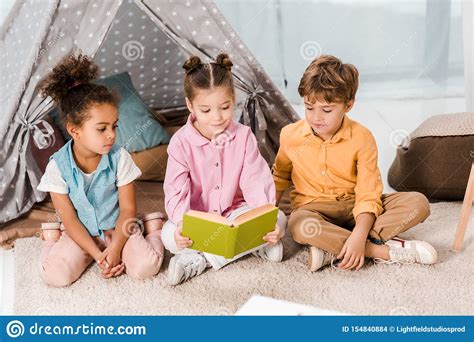 Adorable Little Children Sitting On Carpet And Stock Photo Image Of