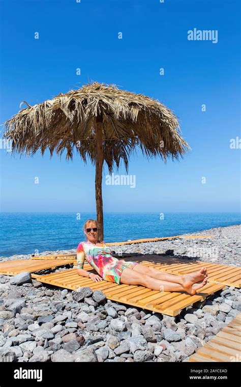 Woman Sunbathes As Tourist On Stony European Beach Stock Photo Alamy