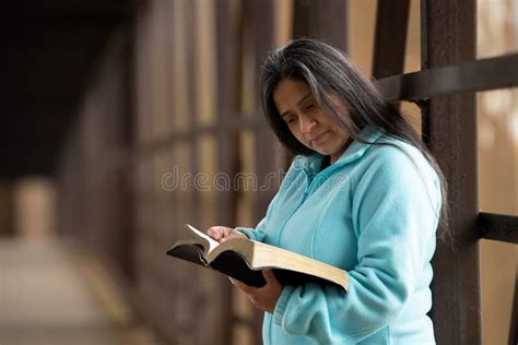 hispanic woman reading bible on bridge stock image image of page spirituality 142902209