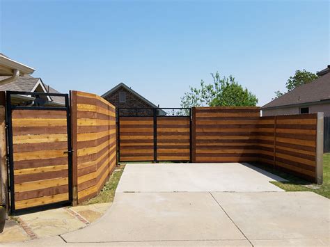 A Wooden Fence In Front Of A House With An Attached Gate And Side Walk Way