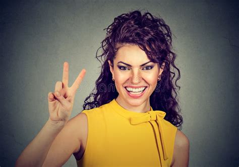 Smiling Woman In Yellow Dress Showing Victory Or Peace Sign Stock Photo