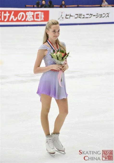 A Woman Standing On Top Of An Ice Rink Holding Flowers