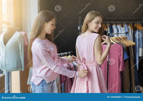 shop assistant tightening bow on dress for pretty customer stock image image of consumerism