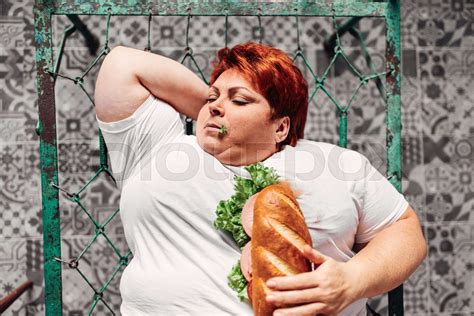 Fat Woman With Sandwich In Hands Liying On The Bed Stock Image Colourbox