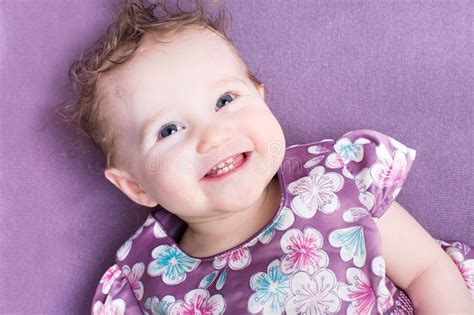 Baby Girl With Curly Hair Wearing A Purple Dress Stock Image Image Of