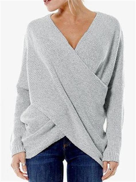 A Woman Wearing A Gray Sweater With An Asymmetrical Twist On The Back
