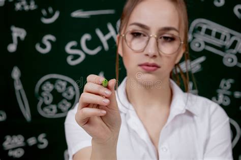 Una Profesora Joven Sentada Cerca De La Pizarra En El Aula Foto De Archivo Imagen De Hembra