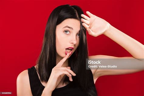 Passionate Brunette Woman Posing On The Red Background In Studio Stock