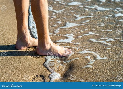 Close Up Of Woman Feet Walking Barefoot On Sand Leaving Footprints On Golden Beach Vacation