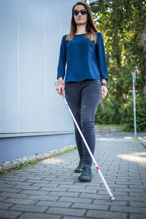 Blind Woman Walking On City Streets Using Her White Cane Stock Photo