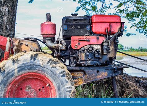 Close Up Of The Old Red Tiller Tractor Or Walking Tractor Parked Under