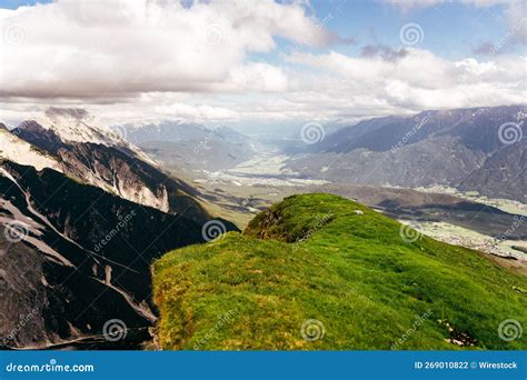 Landscape Of Green Mountain Range And Rocky Hills Under Clouds Stock