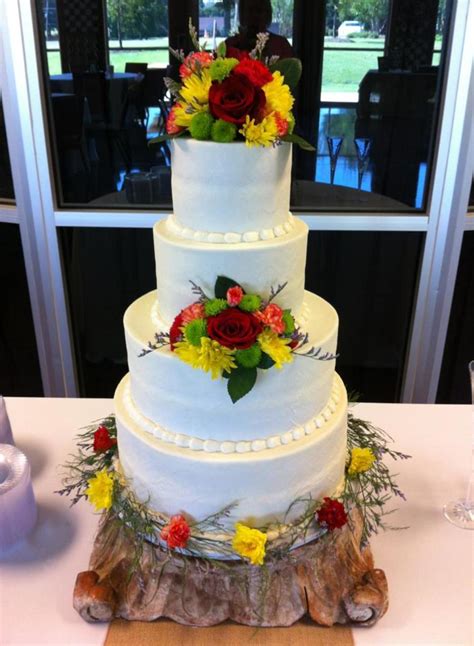 Four Tiered Wedding Cake Covered In Buttercream Icing With