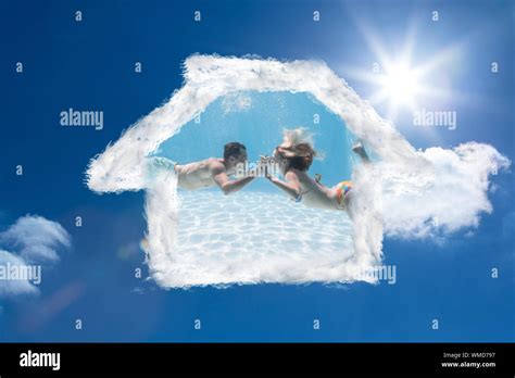 Cute Couple Kissing Underwater In The Swimming Pool Against Bright Blue Sky With Clouds Stock