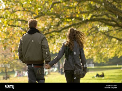 Boy And Girl Young Couple Walking In Park In Autumn Stock Photo Alamy