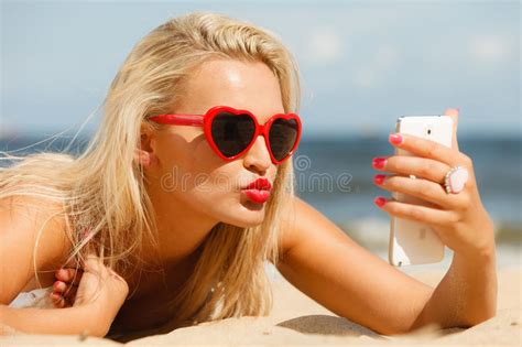 woman lying on sandy beach using cell phone stock image image of taking reading 76593391