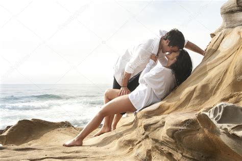 Young Attractive Couple Relaxing Together On Rocks At