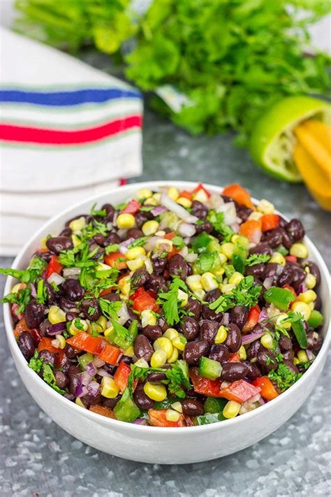 A White Bowl Filled With Black Beans And Veggies
