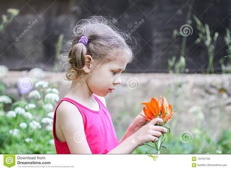Adorable Girl With Orange Lily Flower Outdoors In