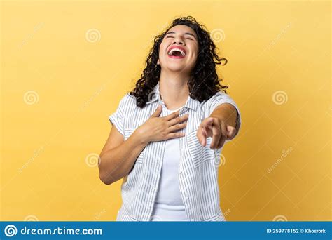 Woman Laughing Out Loud And Pointing Finger To Camera Hearing Funny Joke Holding Belly Stock