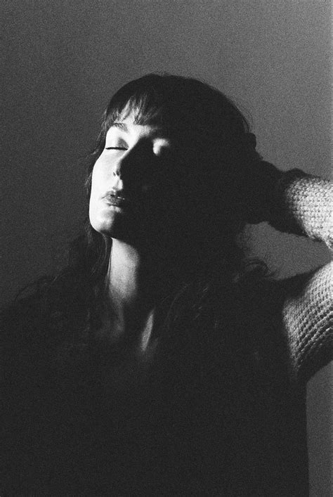 A Black And White Photo Of A Woman With Her Eyes Closed In The Dark