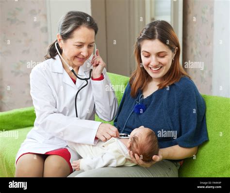 Friendly Mature Childrens Doctor Examining Newborn Baby With