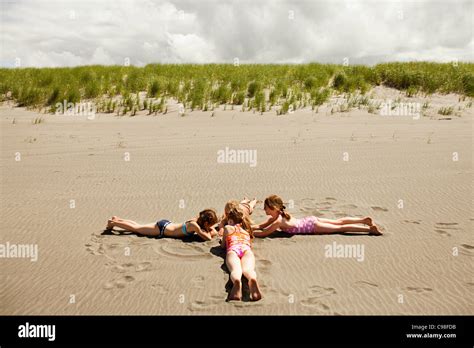 Girls Lying On Sand Beach Stock Photo Alamy