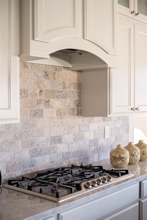 A Full Wall Subway Patterned Silver Travertine Backsplash Is