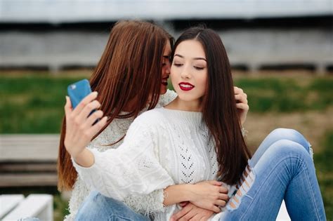 Duas mulheres fazendo selfie no banco do parque Foto Grátis
