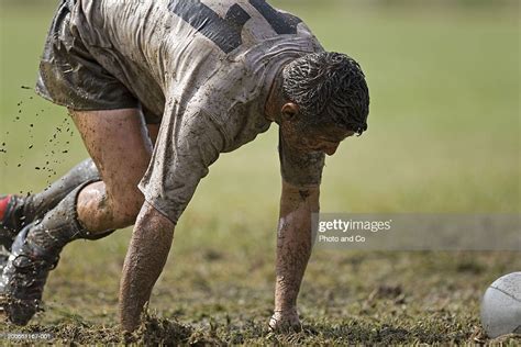 Young Rugby Player Covered In Mud Approaching Ball High Res Stock Photo