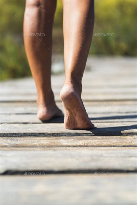 Barefoot Woman Walking On A Wooden Pier Concept Of Nudism And Naturism