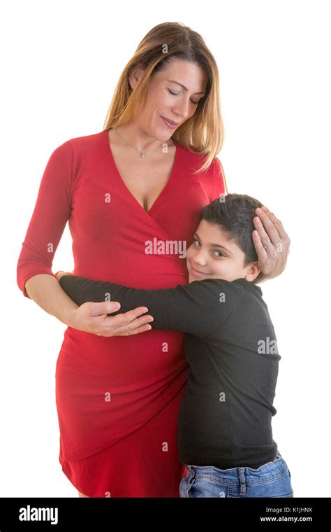 Portrait Of Beautiful Pregnant Mother With His Older Son Holding Her