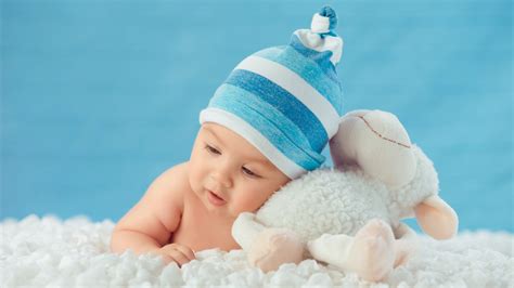 Cute babies photography cute baby wallpaper baby faces. Beautiful Cute Baby Is Lying Down On White Cloth Wearing ...
