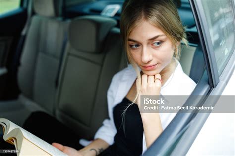 Beautiful Girl Reading Book In The Backseat Of The Car Stock Photo