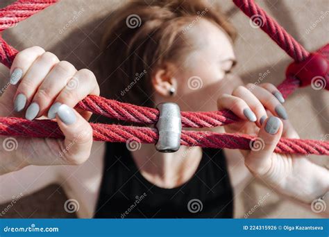A Young Woman Is Lying And Her Hands Are Squeezing A Red Rope Stock